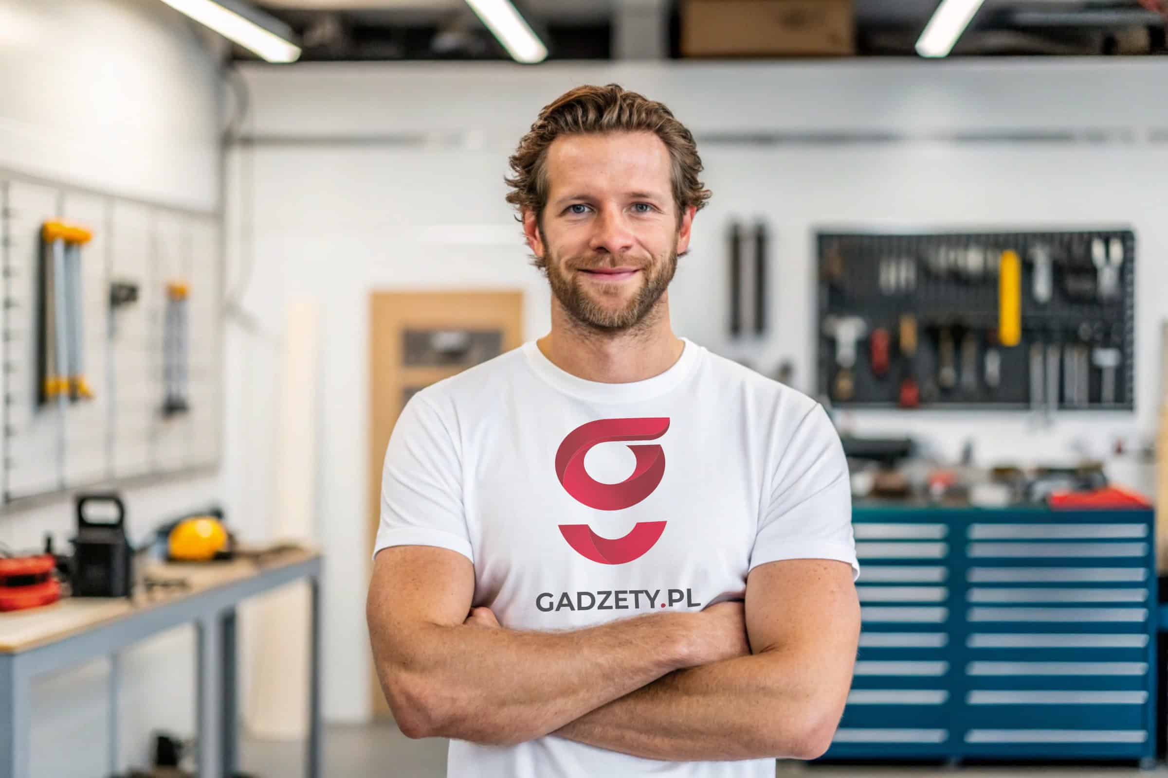 Klimatyczna koszulka z logo gadżety.pl w warsztacie narzędziowym.