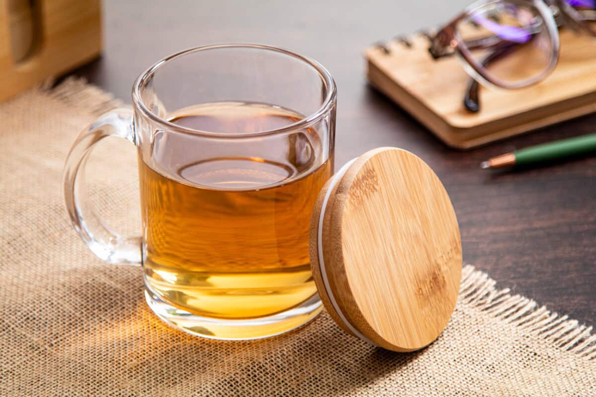 Kubki z logo – strobba szklany kubek z recyklingu AP800576__DG1 Kubek z herbatą i drewniany pokrowiec na kubek, idealny gadżet na prezent lub do domu.