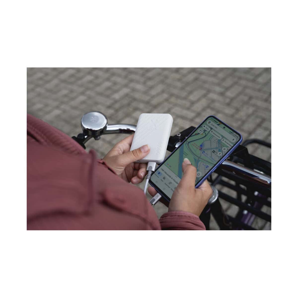 Powerbanki z logo – xtorm xg205 go2 powerbank 12 w 5000 mah z szybkim ładowaniem 12440901_m1 Fotografia osoby korzystającej z powerbanku i nawigacji w telefonie na rowerze.