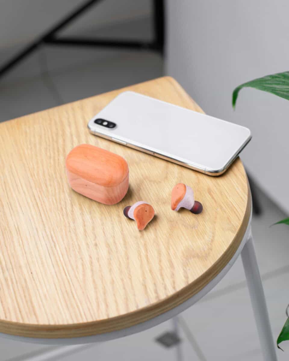 Słuchawki z logo – prixton słuchawki douszne tws163 2pa18571_m2 Gadżety, słuchawki bezprzewodowe, etui, smartfon na drewnianym stoliku.