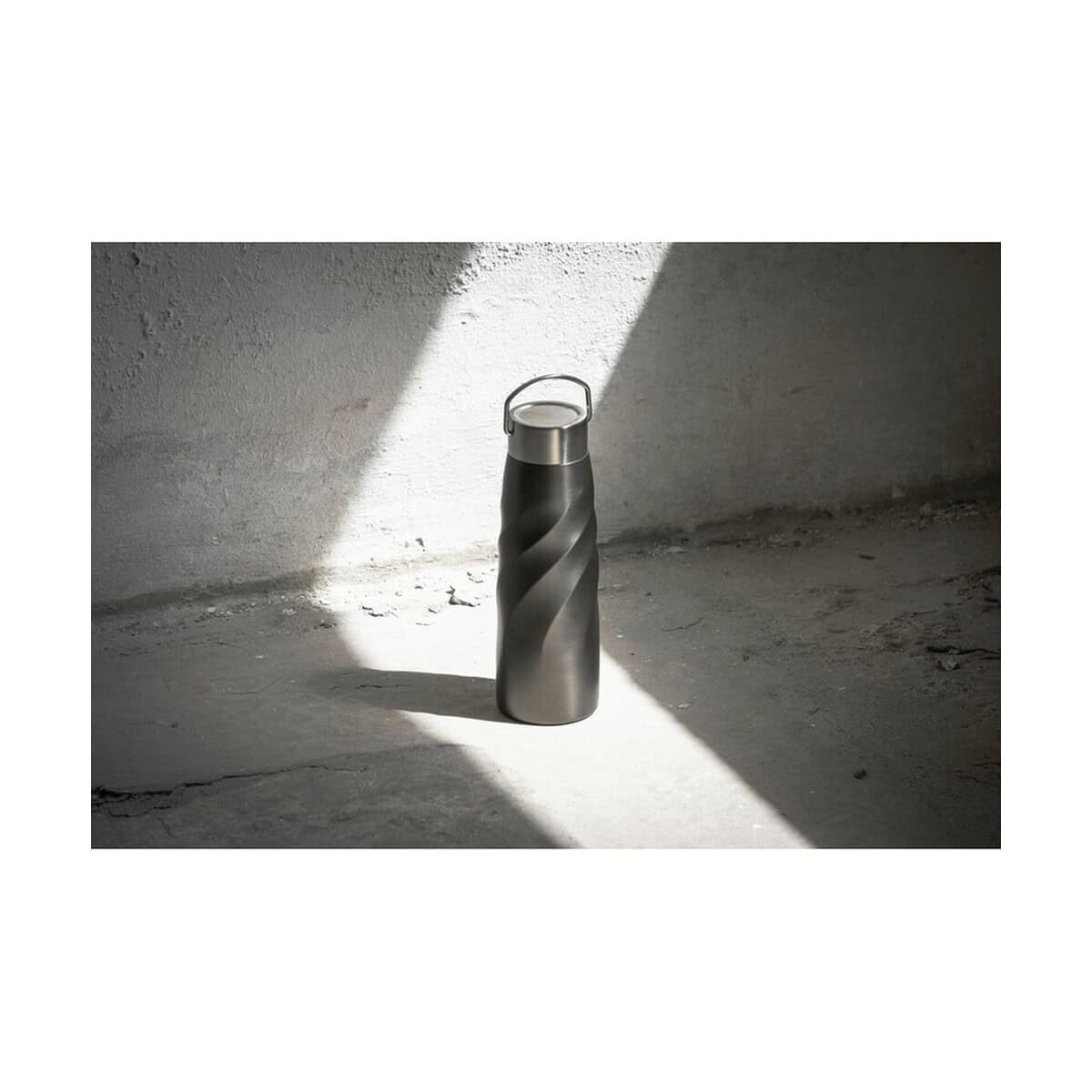 Termosy z logo – butelka termiczna 500 ml brandcharger vortex vita VA542-15_ATM01 Butelka termiczna, stalowa, czarna z szarą spiralą, na tle ściany z cieniem.