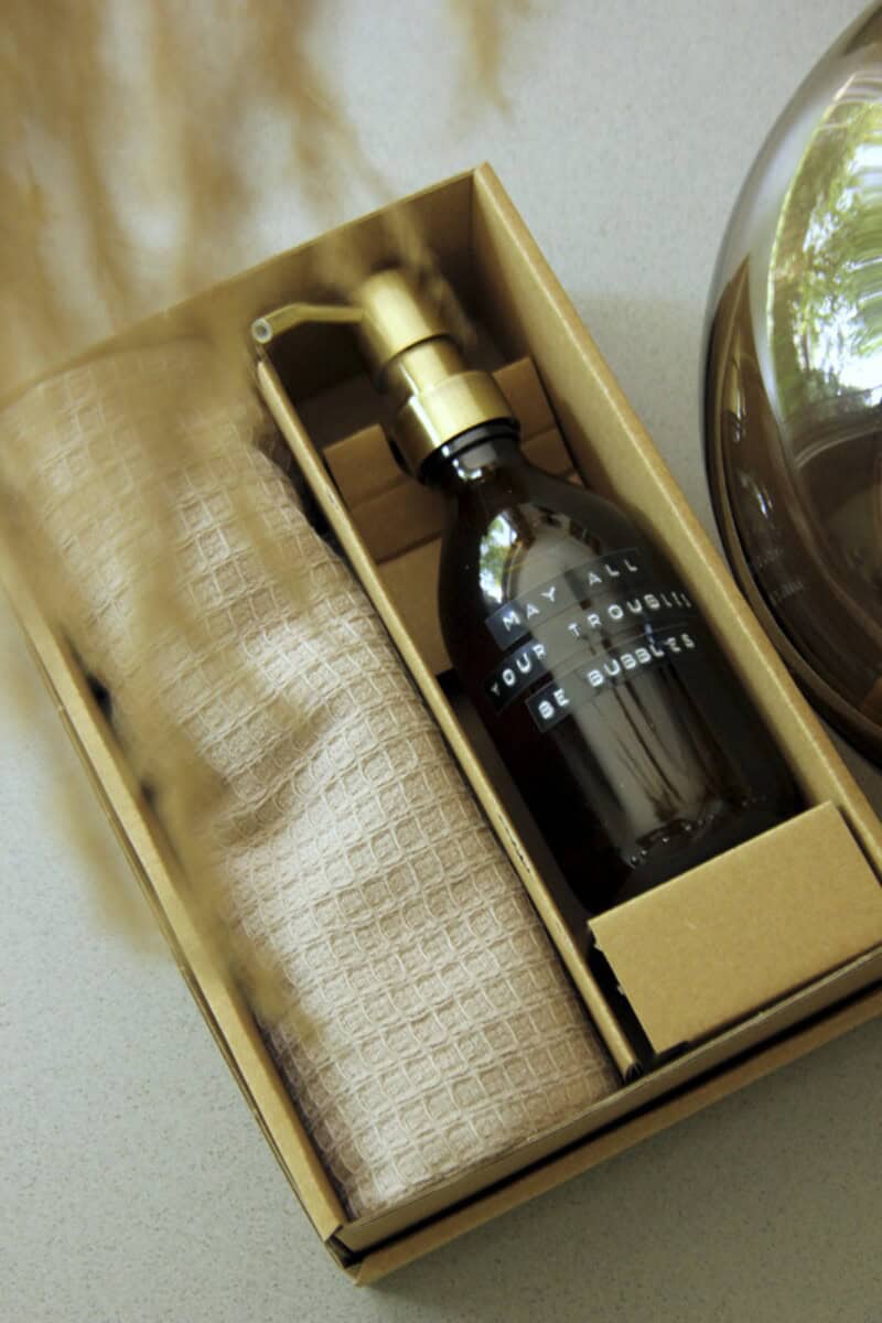 Zestawy prezentowe z logo – wellmark happy home pudełko upominkowe 12632211_m2 Elegancki zestaw upominkowy z personalizowanym spryskiwaczem, ręcznikiem i długopisem z nadrukiem na gadżety firmowe.