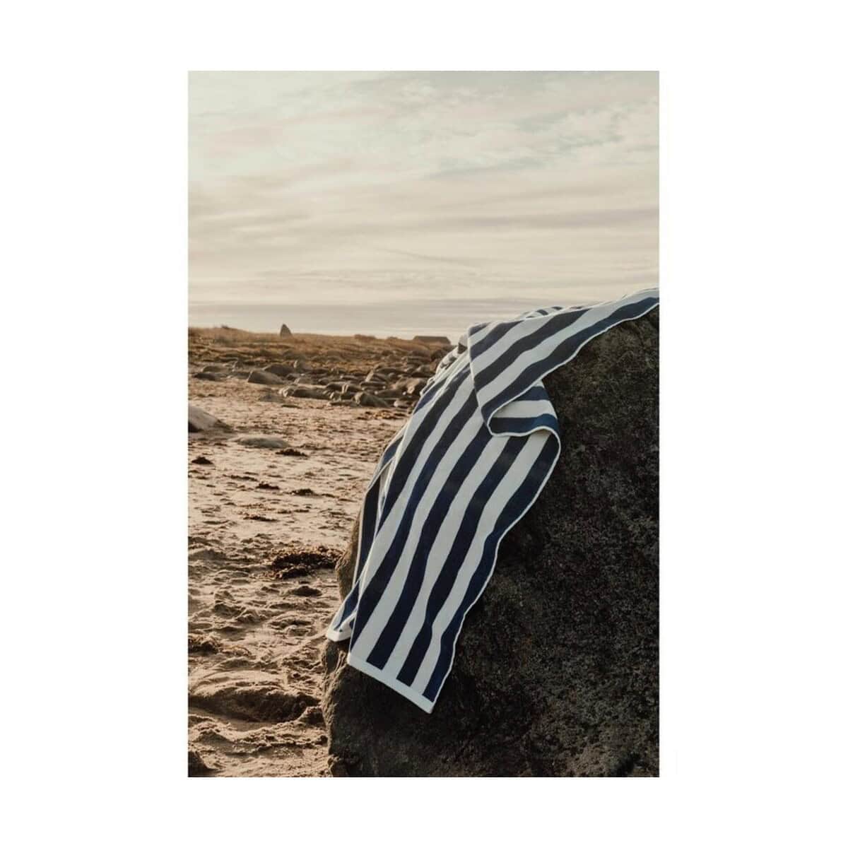 Plażowa chusta na kamieniu Chusta plażowa na kamieniu nad morzem, idealna na lato.